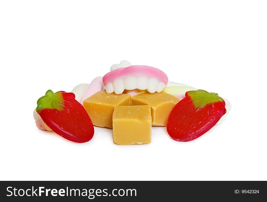 Gluttony concept - candy false denture eating a mix of jelly fruits, marshmallow sweets and vanilla toffee. Isolated on white. Gluttony concept - candy false denture eating a mix of jelly fruits, marshmallow sweets and vanilla toffee. Isolated on white.