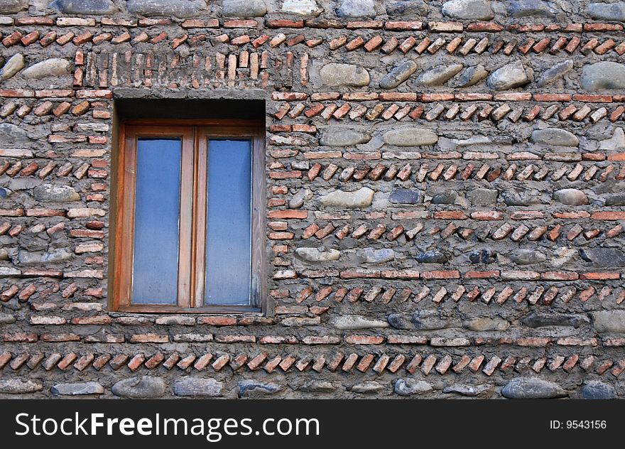 Window on the ancient wall with unusual brickwork