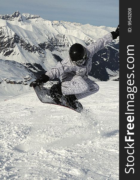 Snowboarder in black and white jacket flying over the slope. Snowboarder in black and white jacket flying over the slope