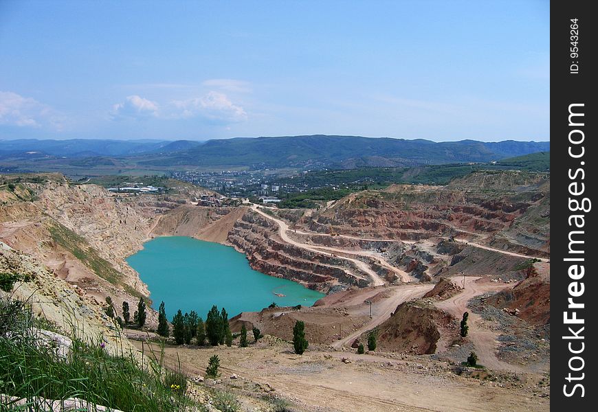Panoramic view to the abandoned quarry with the blue lake inside. Panoramic view to the abandoned quarry with the blue lake inside