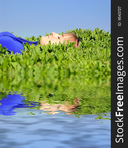 The teenager lays in a spring grass. The teenager lays in a spring grass