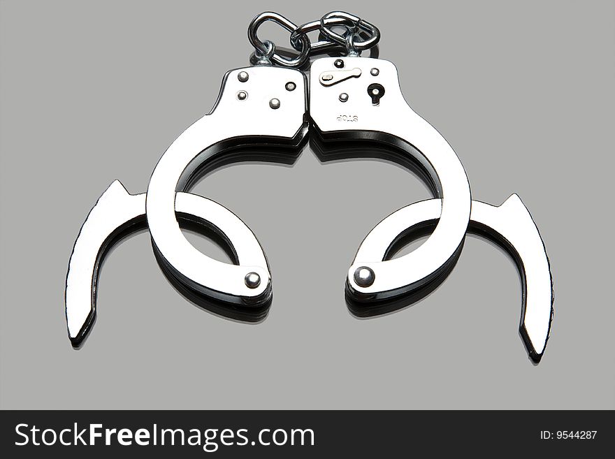 Handcuffs placed on a reflective tabletop