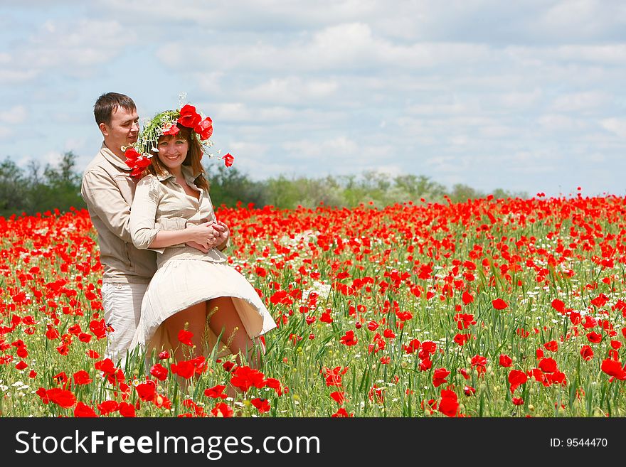 Happy couple on red poppies field