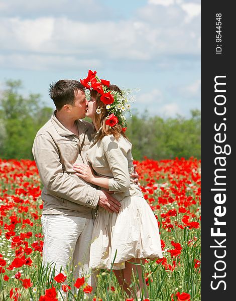 Happy couple on red poppies field