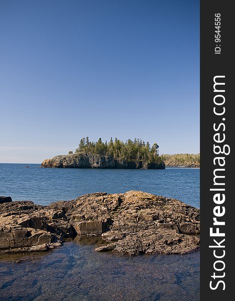 A tree covered island offshore in Lake Superior. A tree covered island offshore in Lake Superior.