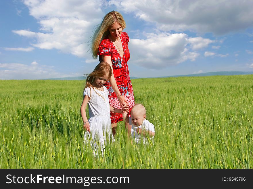 Mother and two children in green field. Mother and two children in green field