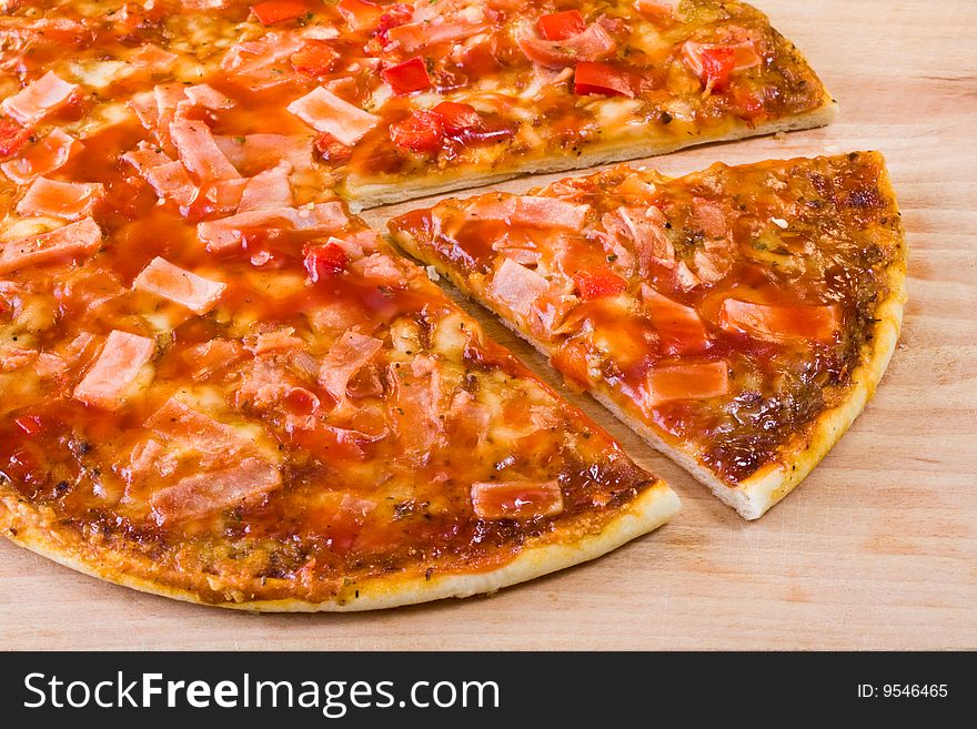 Hot sliced pepperoni pizza on wooden chopping board