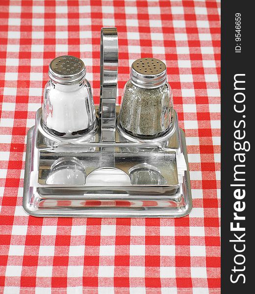 Salt, pepper and toothpicks on table with red checked tablecloth. Salt, pepper and toothpicks on table with red checked tablecloth