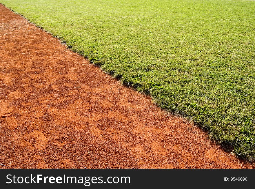 Grass and red running cinder in diagonal