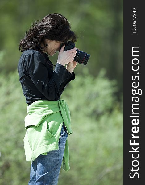 Pretty female photographer in a forest.