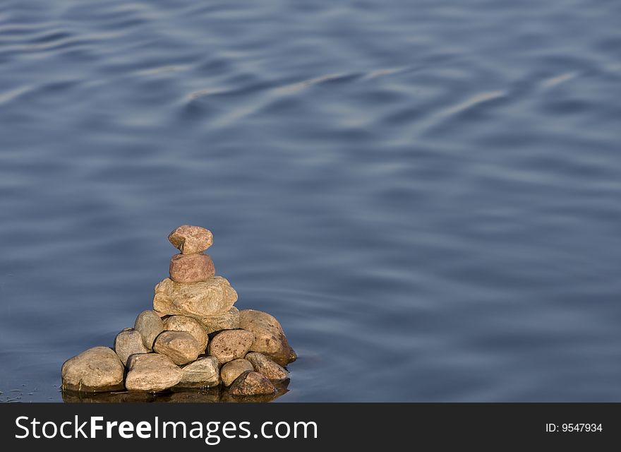 Pyramid of stones on a background surface of the water