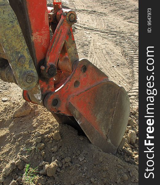 The shovel of a large bulldozer digs into the ground. The shovel of a large bulldozer digs into the ground.