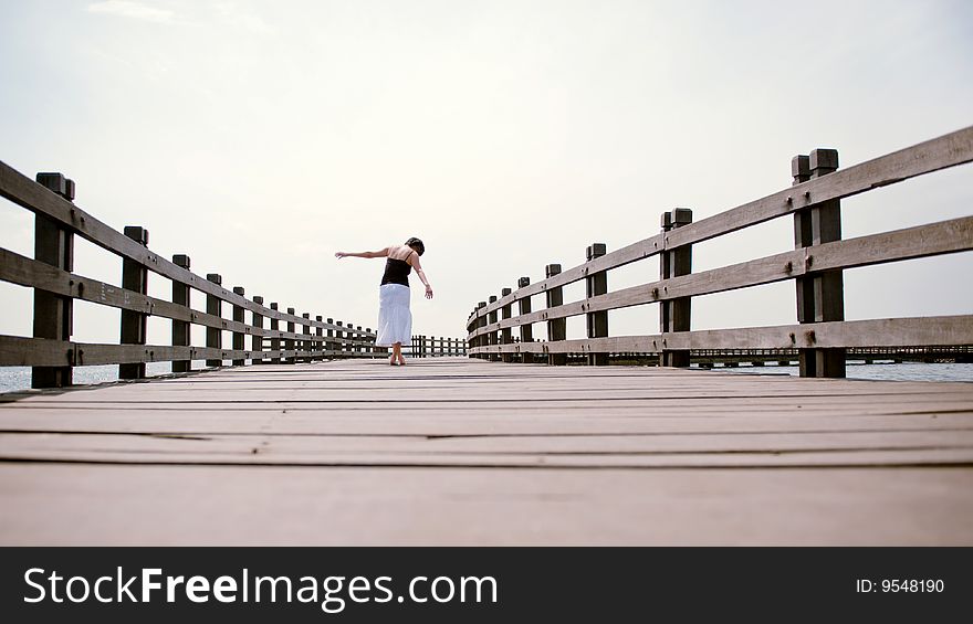 Girl Balances Along Empty Pier