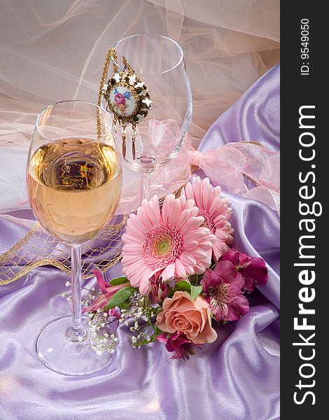 Two glasses, flowers and medallion on the fabric. Two glasses, flowers and medallion on the fabric