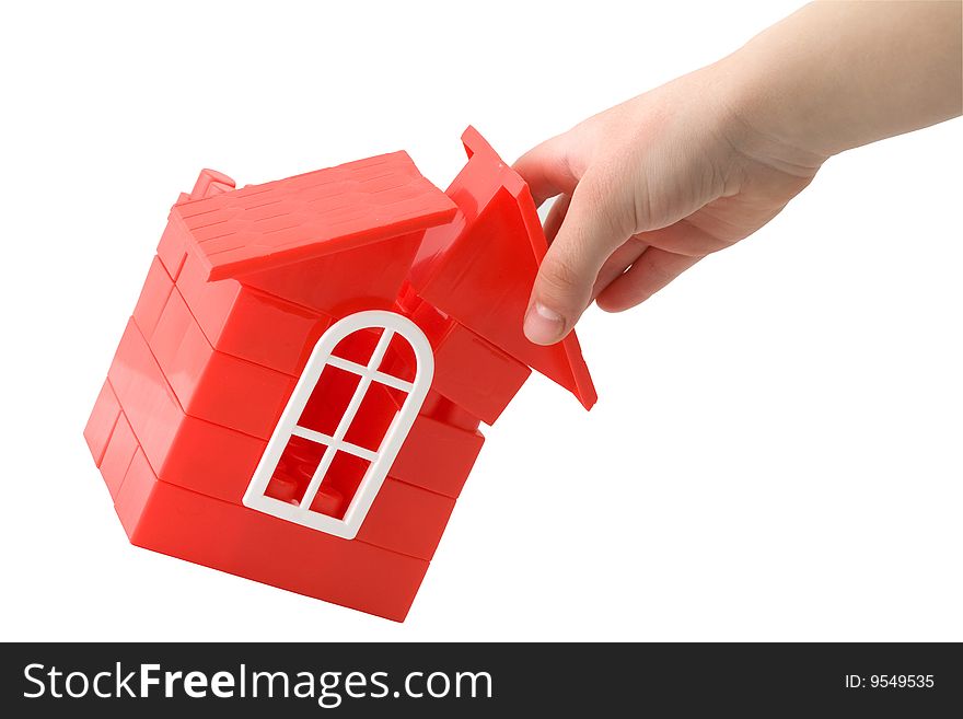 A child's hand holding a doll`s house made of plastic details for designing on a white background. A child's hand holding a doll`s house made of plastic details for designing on a white background