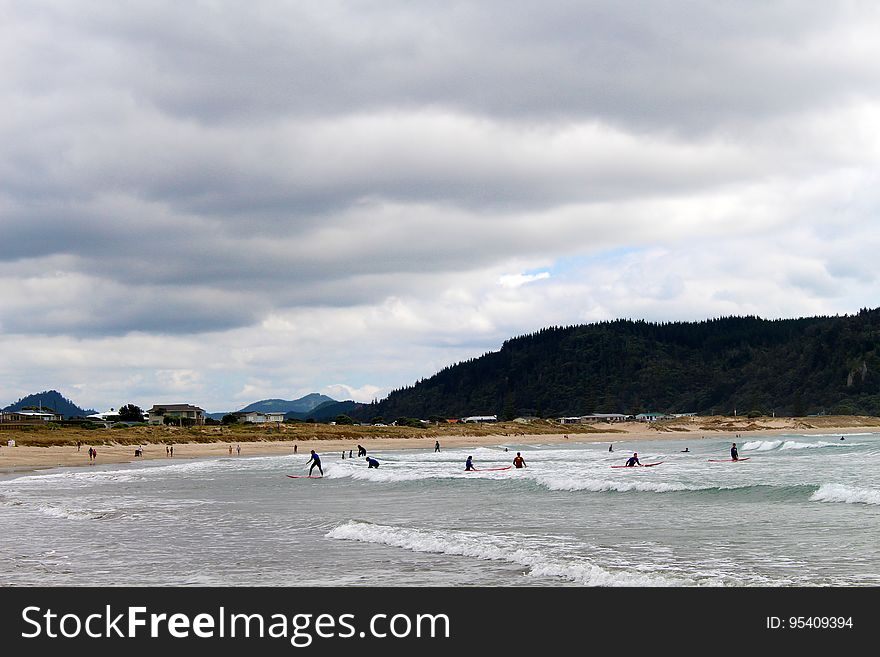 Surfers On Whangamata Beach In New Zealand
