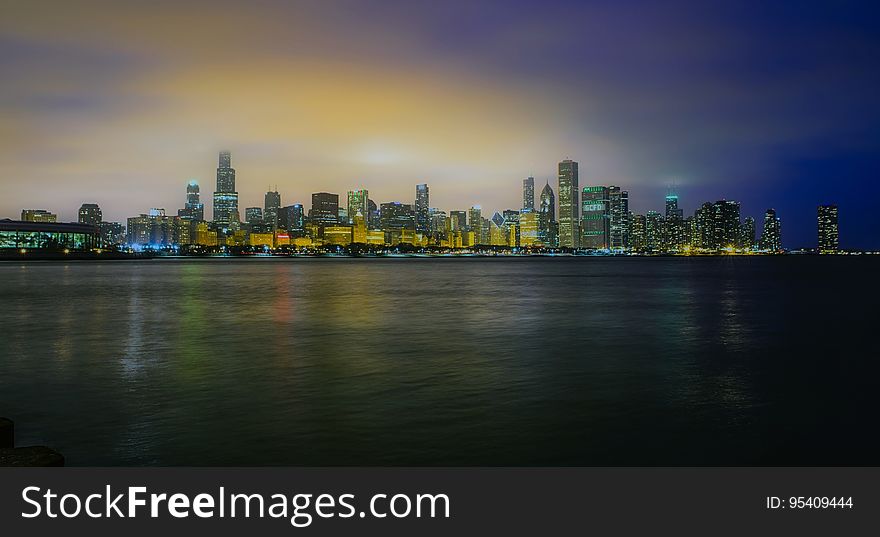 Waterfront city skyline illuminated at dawn. Waterfront city skyline illuminated at dawn.