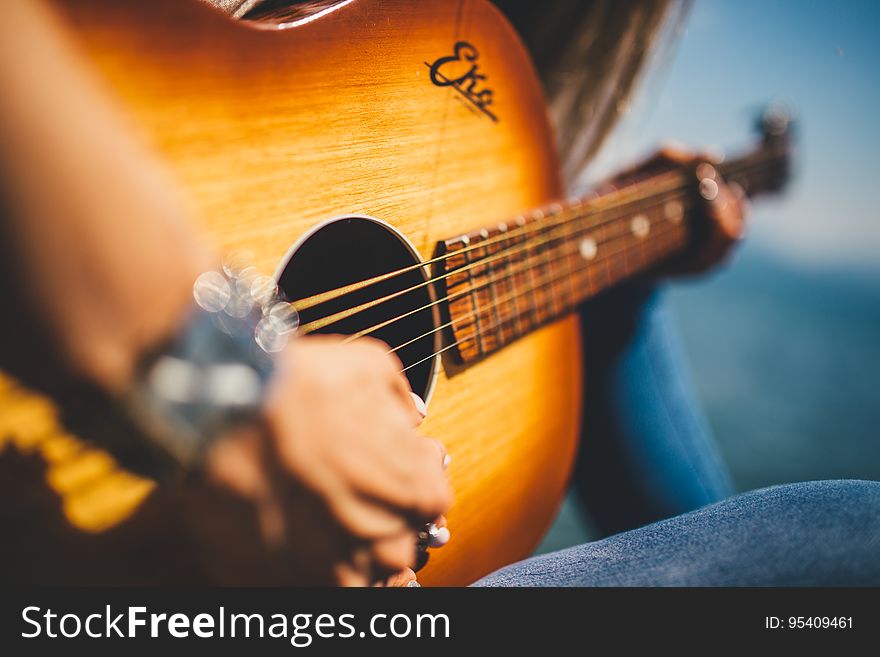 A close up of a woman playing the acoustic guitar. A close up of a woman playing the acoustic guitar.