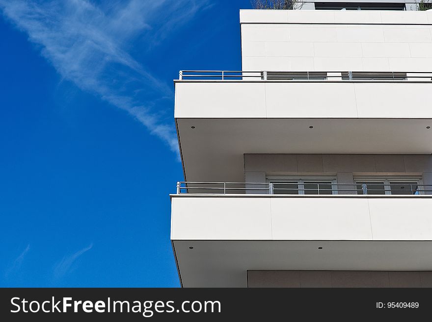 A generic apartment building with balconies against the blue sky. A generic apartment building with balconies against the blue sky.