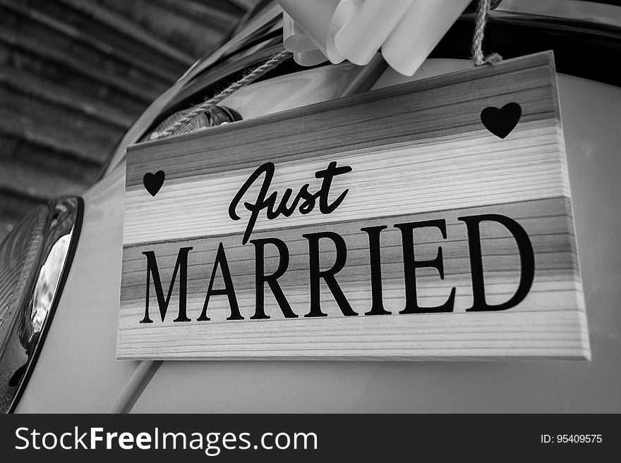 Just married on wooden sign hanging on car in black and white. Just married on wooden sign hanging on car in black and white.