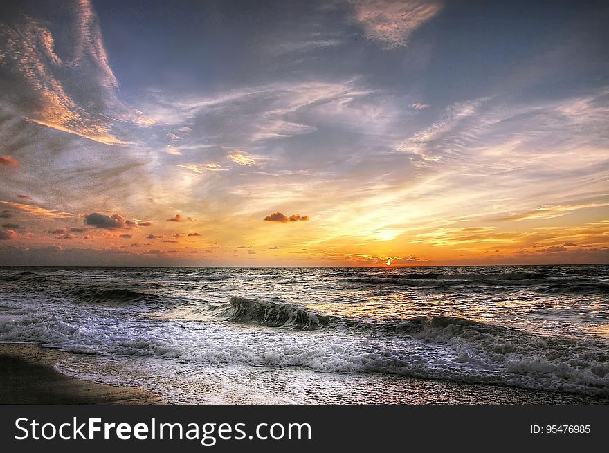 A sunset on the sea with waves coming ashore. A sunset on the sea with waves coming ashore.