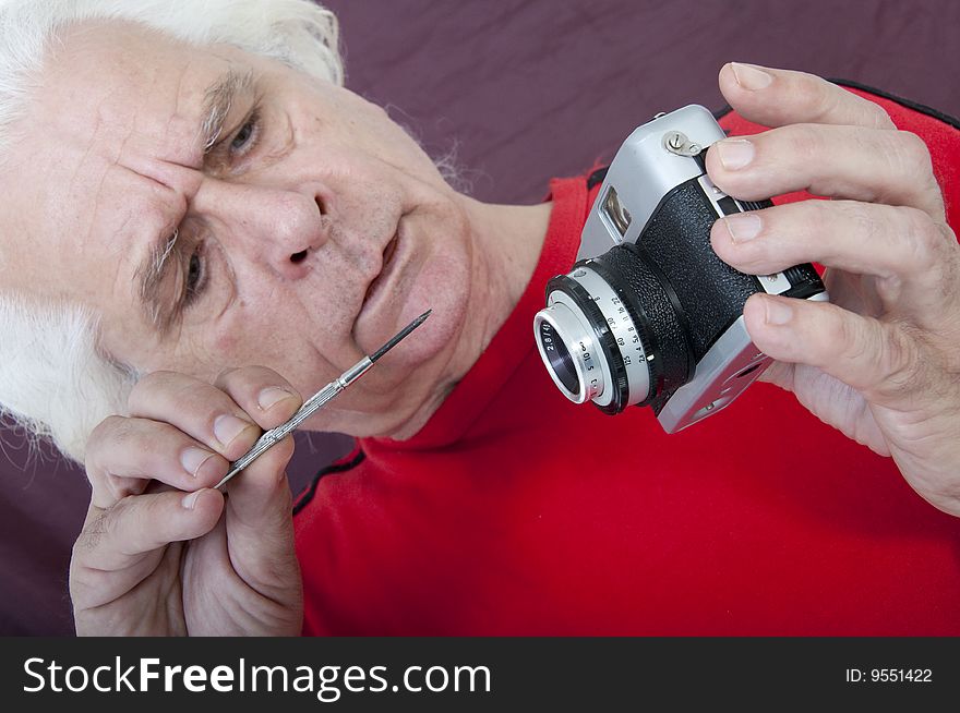 Older man fixing his broken camera