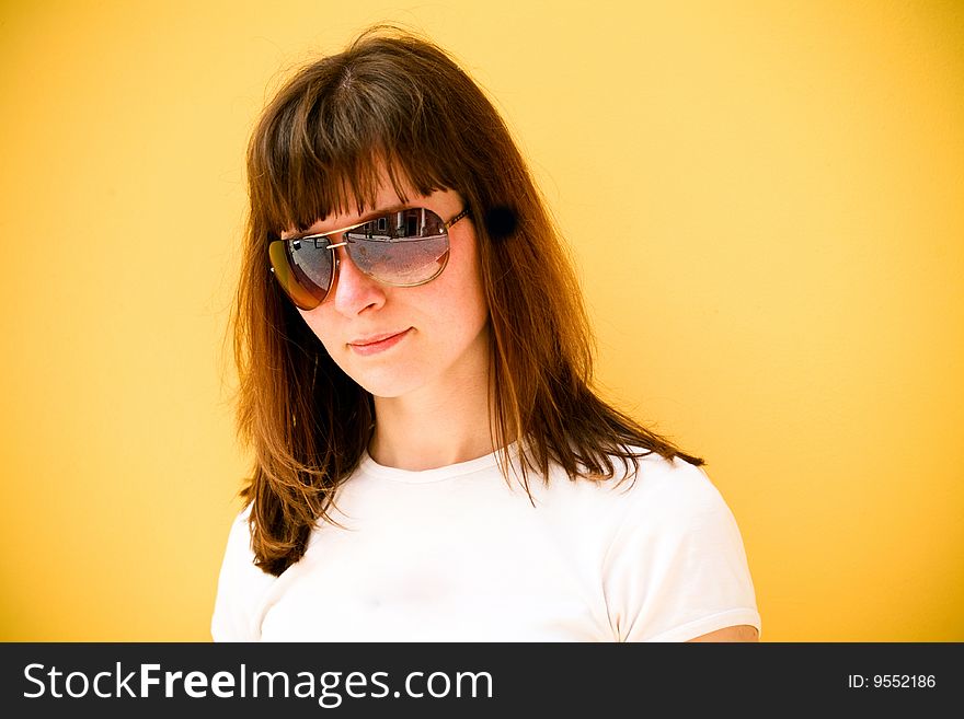 Beautiful young woman portrait on yellow sunny background