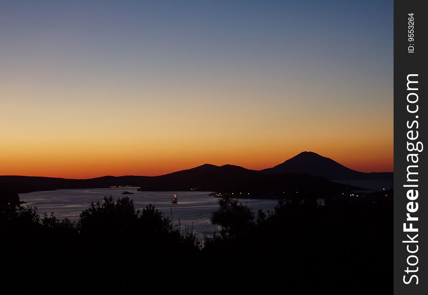 Sunset over city Mali Losinj in Croatia. Silhouette of mountains beautiful color palette. Sunset over city Mali Losinj in Croatia. Silhouette of mountains beautiful color palette.