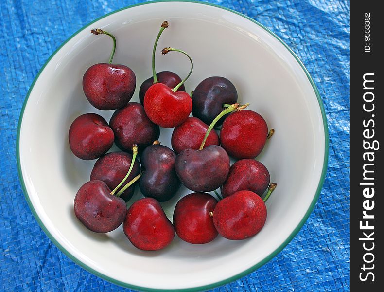 Red cherries in green rimmed bowl