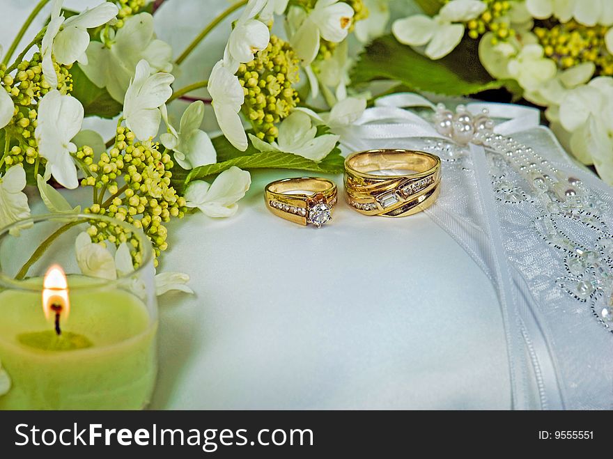 Wedding rings on bridal pillow with candle. Wedding rings on bridal pillow with candle.