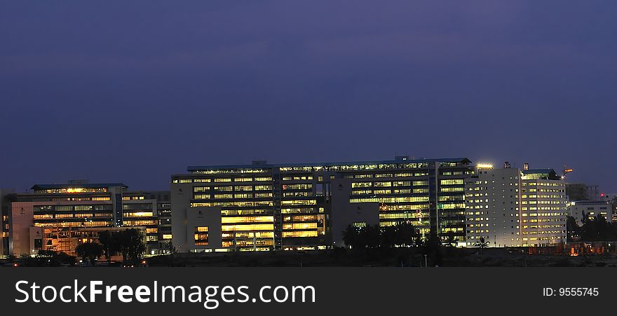 Panoramic view of an office building brightly lit at evening time. Panoramic view of an office building brightly lit at evening time.