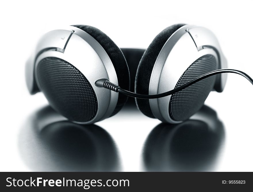 Modern headphones on white background with reflection