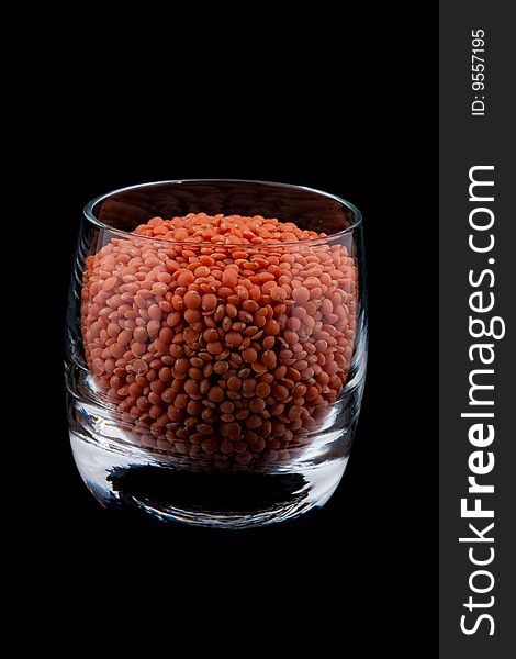 Red lentils in glass, isolated on black background. Red lentils in glass, isolated on black background