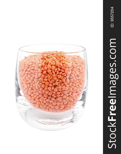 Red lentils in glass, white background