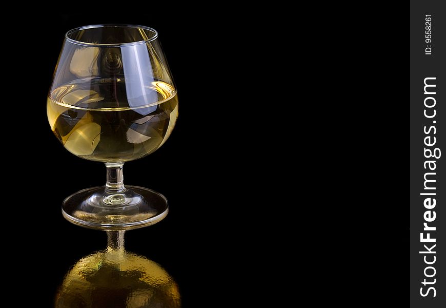 One glass white wine on black background, with room for text.
