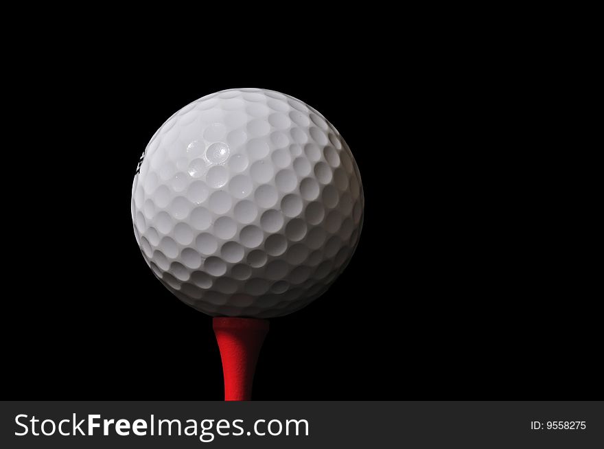 Golf ball and tee isolated on black - clipping path included. Golf ball and tee isolated on black - clipping path included