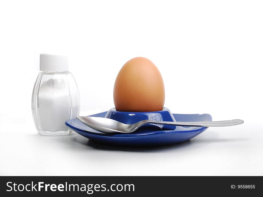 Egg standing.cardboard egg support with salt.brown egg on a white background.