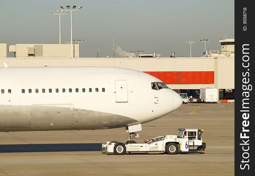 Passenger airplane being pulled at airport. Passenger airplane being pulled at airport