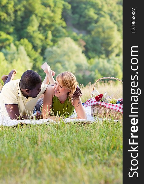 Portrait of young multiethnic couple picnicking in park