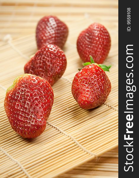 Fresh strawberries in rows on a bamboo mat