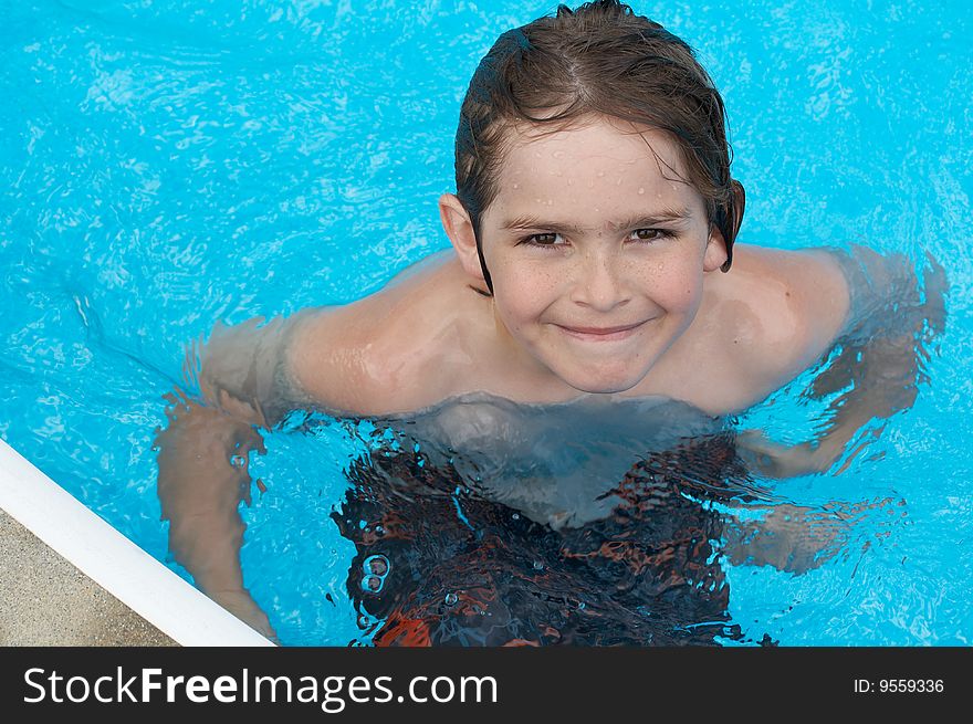 A young boy in pool with goggles on. A young boy in pool with goggles on