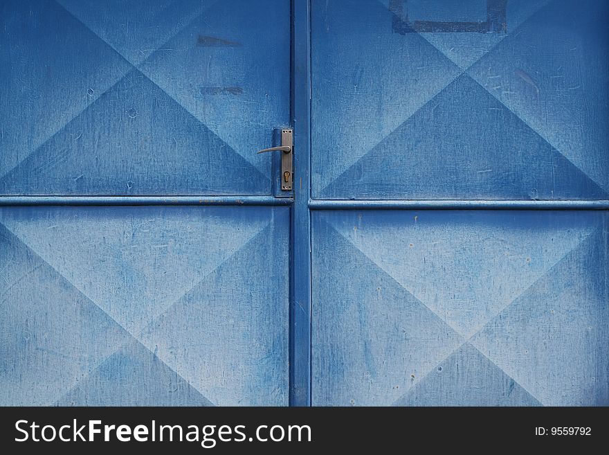 Old garage door with nicely diluted blue colour, frame fully filled, possible to use like a background or wallpaper.