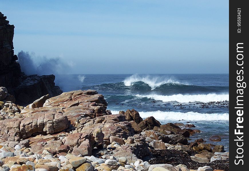 A rocky coast with waves coming ashore.
