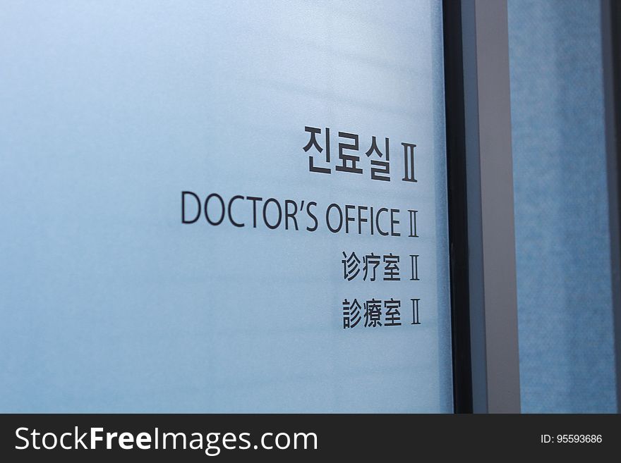 Doctor's Office in black text with Asian language characters on frosted glass door. Doctor's Office in black text with Asian language characters on frosted glass door.