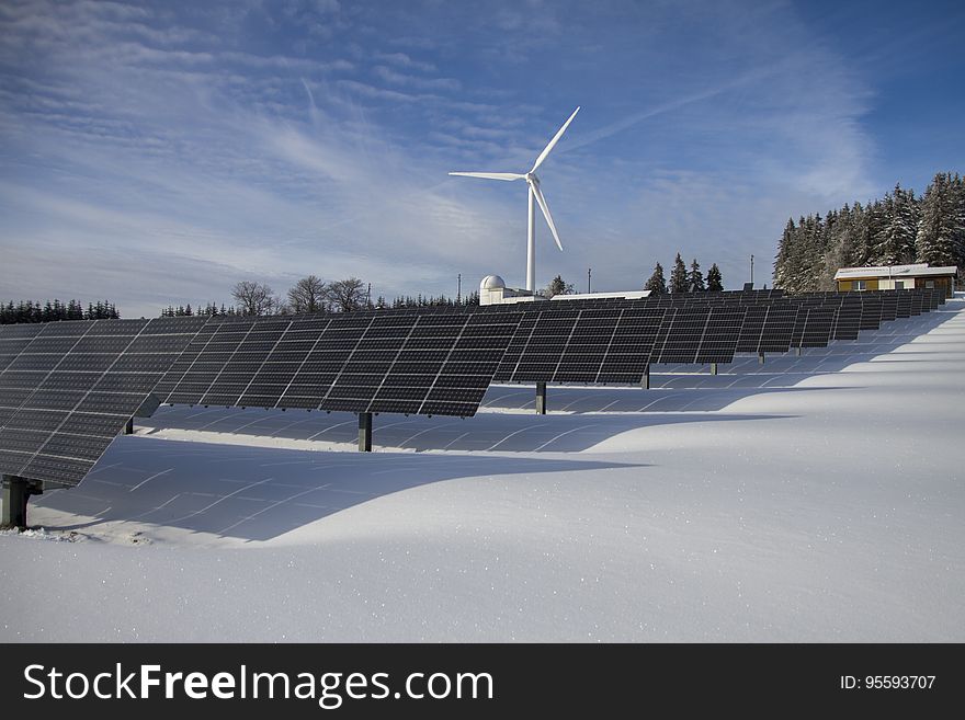 Snowy landscape with solar power panels and wind turbine on sunny day. Snowy landscape with solar power panels and wind turbine on sunny day.