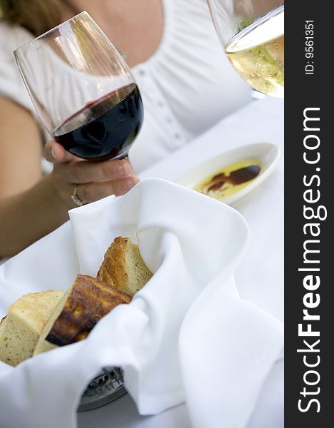 Bread basket at a table setting with wine and dipping oil. Bread basket at a table setting with wine and dipping oil