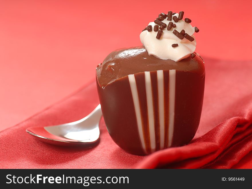 Chocolate pudding in a dark and white chocolate cup with whipped cream. Chocolate pudding in a dark and white chocolate cup with whipped cream