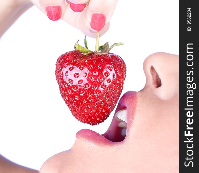 Brunette girl eating a strawberry