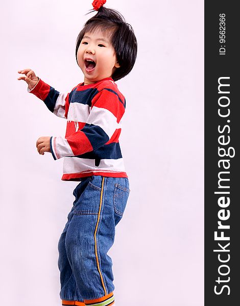 Picture of a little chinese girl with pigtail jumping and laughing happily