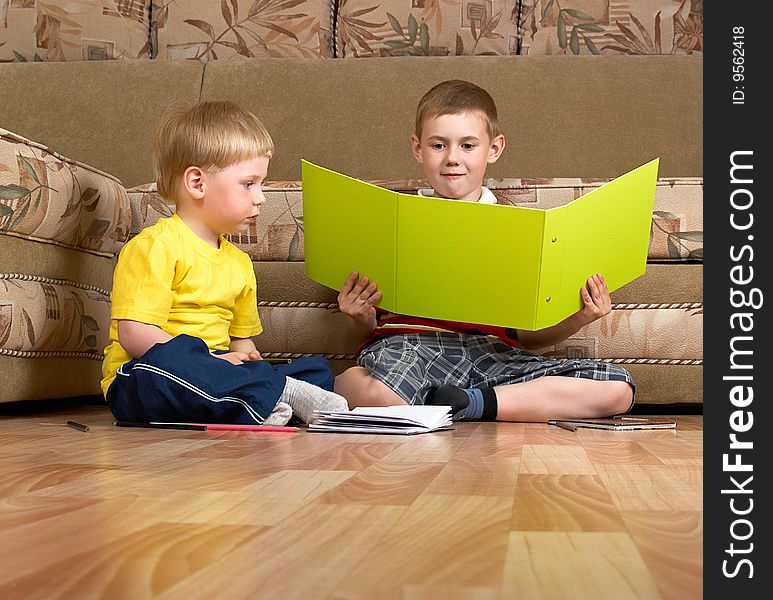 Two small boys are engaged at home on a floor. Two small boys are engaged at home on a floor